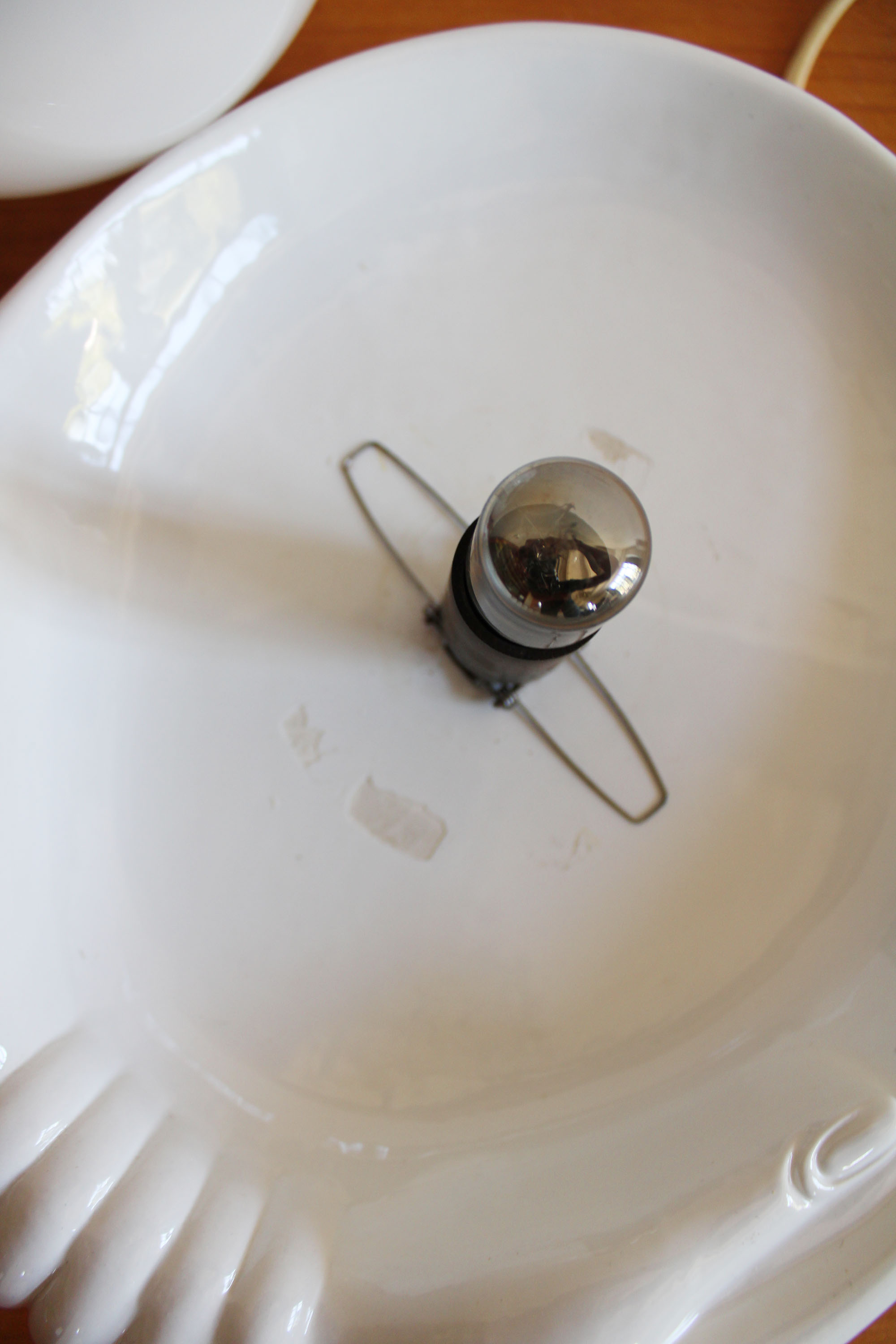 Witte vintage tafellamp, handen met bal. Keramieken retro bol lamp