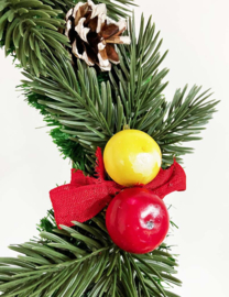 Vintage kerstkrans met dennenappels, fruit en rode linten. Retro kerstversiering