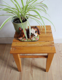 Klein houten krukje met latjes blad. Retro plantentafeltje