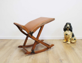 Vintage voetenbankje met bruine skai bekleding. Houten retro schommelbankje