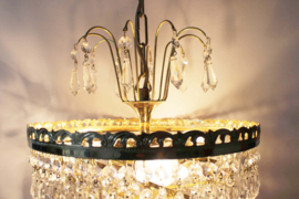 Goudkleurige kroonluchter met pegels in swirl. Hollywood Regency hanglamp