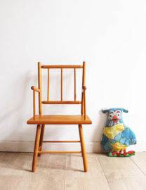 Koddig houten vintage kinder stoeltje met armleuningen.