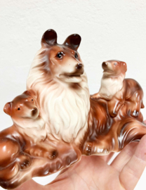 Stenen vintage honden beeldje. Retro beeld van een Collie met puppy's