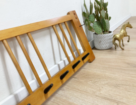 Vintage wandkapstok met zwarte haken. Houten retro kapstok