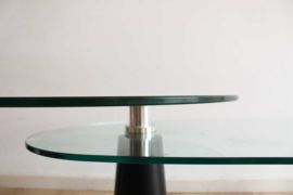 Glazen vintage salontafel op zwarte poten. Retro design tafel met draaibaar blad
