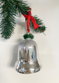 Grote glazen vintagekerstklok met rood lint.