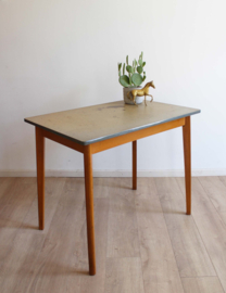 Houten vintage tafel met gespikkels blad. Retro eettafel.