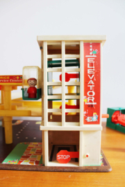 Vintage Fisher-Price garage met auto's en poppetjes.