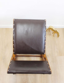 Houten retro schommelbankje. Vintage voetenbankje met bruine skai bekleding.