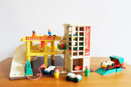 Vintage Fisher-Price garage met auto's en poppetjes.
