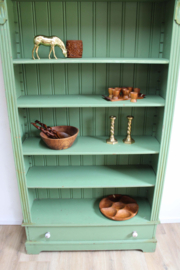Goene vintage boekenkast. Houten keukenkast met planken en lade