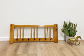 Vintage wandkapstok met zwarte haken. Houten retro kapstok