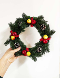 Vintage kerstkrans met dennenappels, fruit en rode linten. Retro kerstversiering