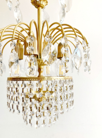 Goudkleurige vintage kroonluchter met pegels. Hollywood Regency hanglamp