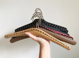 9 vintage kledinghangers van skai leer. Set retro kleerhangers o.a. met studs