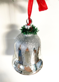 Grote glazen vintagekerstklok met rood lint.