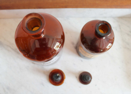 Twee originele apothekersflessen met dop. Bruine vintage stopfles met etiket