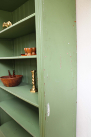 Goene vintage boekenkast. Houten keukenkast met planken en lade