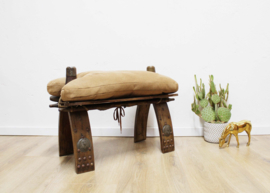 Vintage kamelenzadel kruk met bruin kussen. Houten Boho voetenbankje