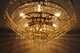 Grote vintage kroonluchter met pegels. Goudkleurige Hollywood Regency hanglamp