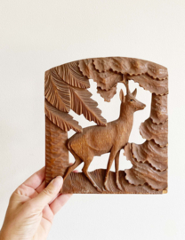 Houten vintage relief paneel van een hertje in het bos. Retro houtsnijwerk