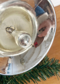 Grote glazen vintagekerstklok met rood lint.
