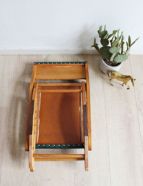 Vintage voetenbankje met groene skai bekleding. Houten retro schommelbankje