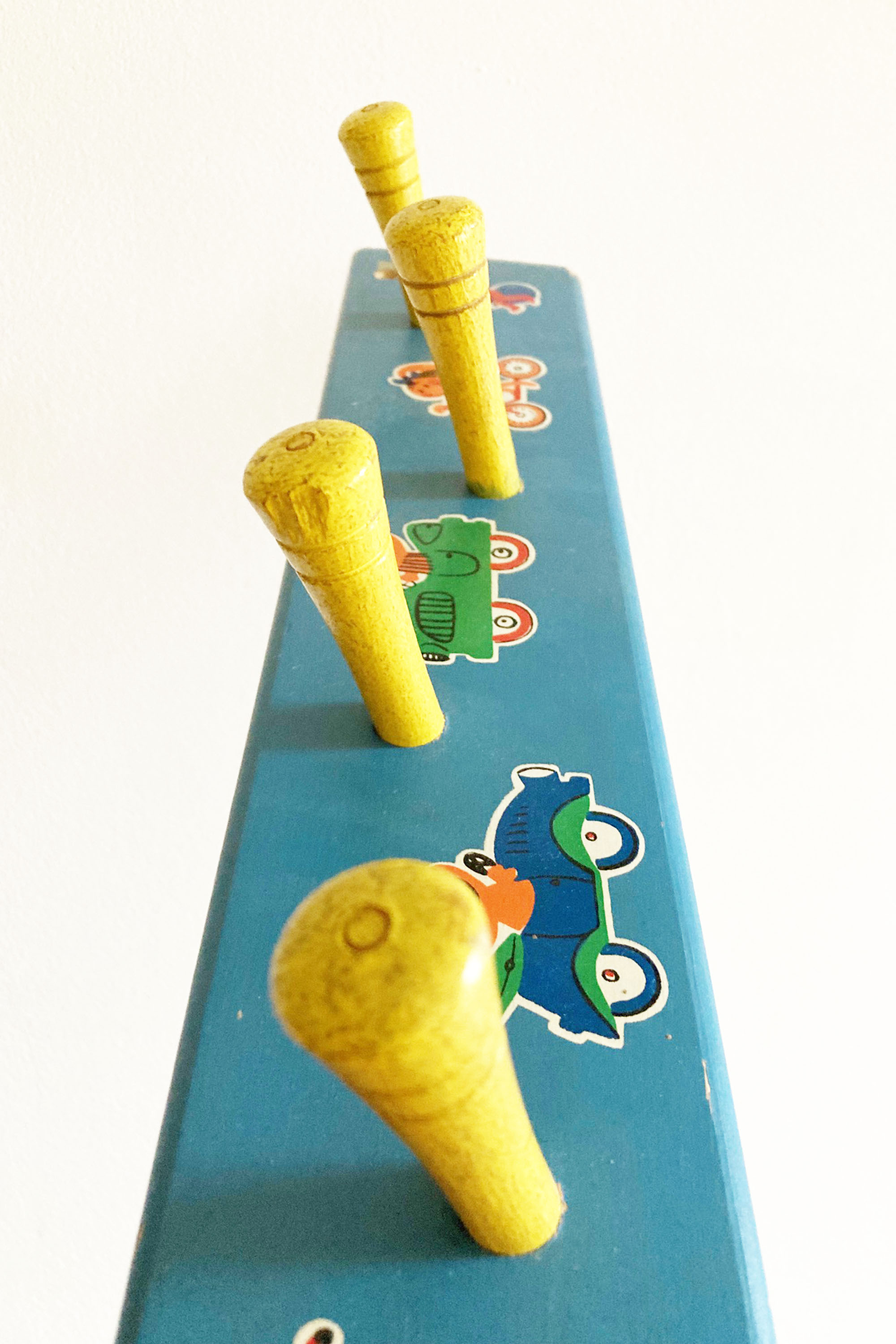 Blauwe vintage kapstok met gele haken. Houten retro kapstokje voor kids