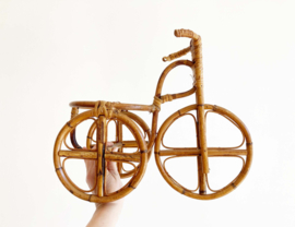 Rotan bloempot in de vorm van een fiets. Vintage plantenstandaard