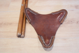 Houten vintage krukje met lederen zitting. Opvouwbare retro kruk, tripod