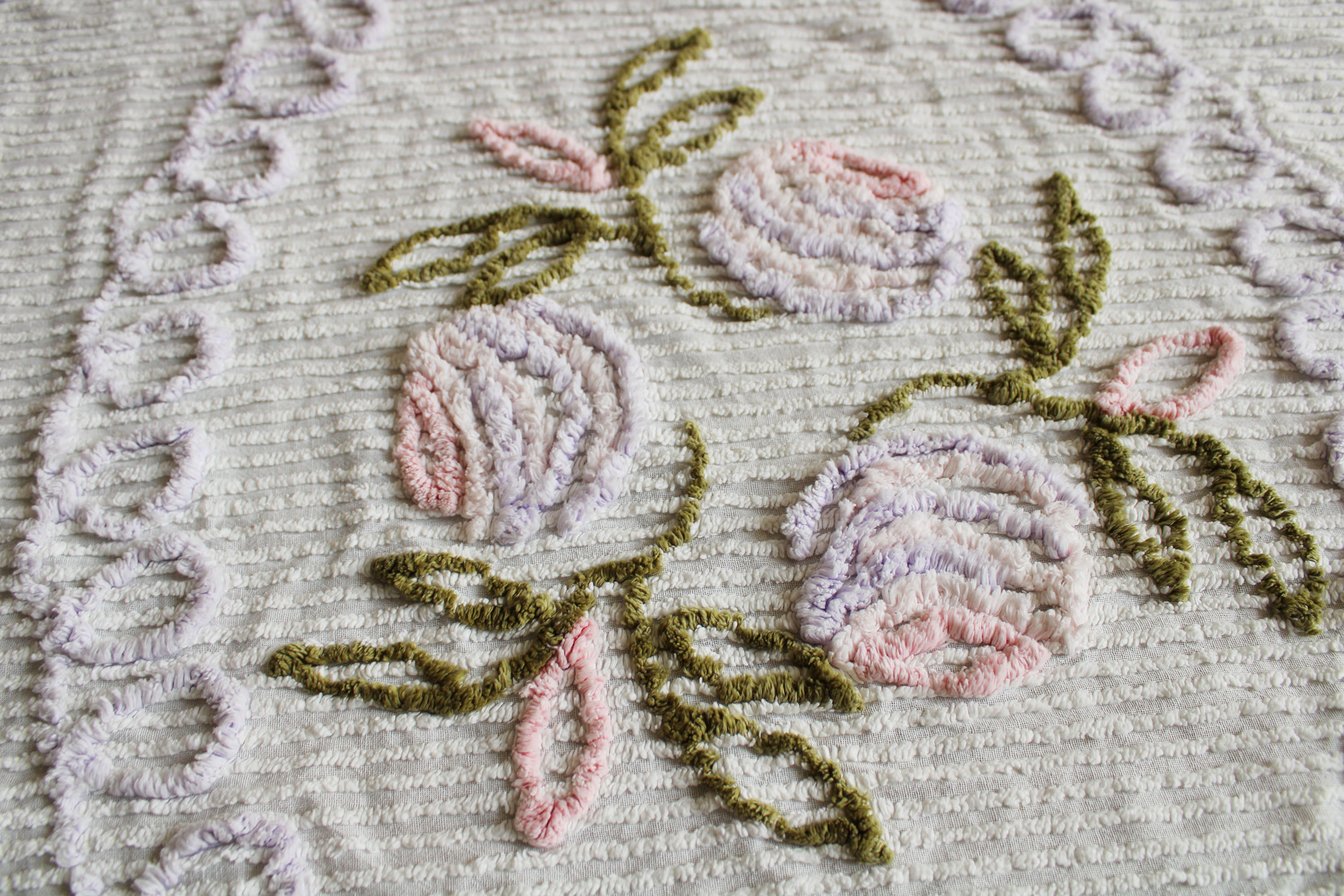 Witte vintage chenille sprei met bloemen. Retro sierdeken.