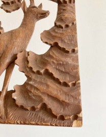 Houten vintage relief paneel van een hertje in het bos. Retro houtsnijwerk