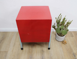 Rozig rood retro nachtkastje. Houten vintage kastje op metalen poten