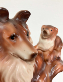 Stenen vintage honden beeldje. Retro beeld van een Collie met puppy's