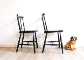 Set zwarte vintage spijlenstoelen. 2 houten retro stoelen.
