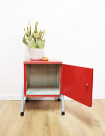 Rozig rood retro nachtkastje. Houten vintage kastje op metalen poten