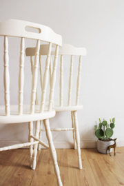 Set witte vintage spijlenstoelen. Twee houten retro stoelen.