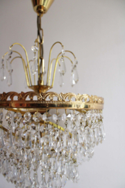 Goudkleurige kroonluchter met pegels in swirl. Hollywood Regency hanglamp