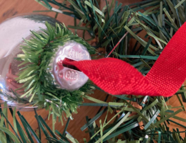 Zilveren kerstballen aan rood lint. Vintage kerstdecoratie.