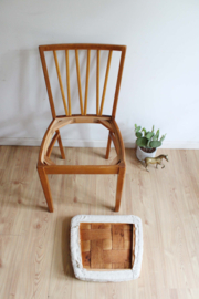 Houten vintage spijlenstoel. Retro stoel met beige zitting