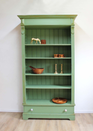 Goene vintage boekenkast. Houten keukenkast met planken en lade