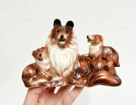 Stenen vintage honden beeldje. Retro beeld van een Collie met puppy's