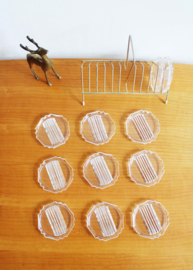 Set vintage onderzettertjes van glas in houder. 11 glazen onderzetters