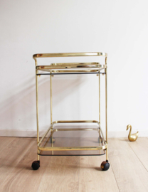 Gouden vintage trolley / bijzettafel met rookglazen bladen. Vintage sidetable