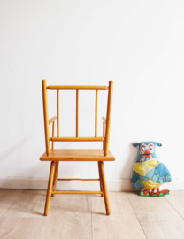 Koddig houten vintage kinder stoeltje met armleuningen.