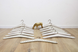 13 vintage kledinghangers van wit skai leer. Set retro kleerhangers met studs
