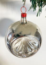 Zilveren deukbal met sterren. Glazen retro kerstbal met rood dopje