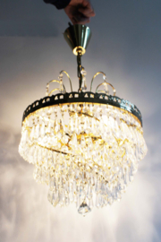 Goudkleurige kroonluchter met pegels in swirl. Hollywood Regency hanglamp