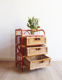 Rotan vintage kastje met rode details en 3 lades. Boho nachtkastje / retro ladekast