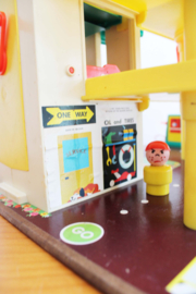 Vintage Fisher-Price garage met auto's en poppetjes.